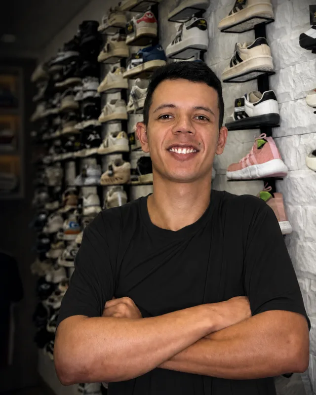 Gabriel Campos dentro da loja, próximo às prateleiras de tênis